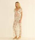 Woman wearing a white floral dress on a beige background